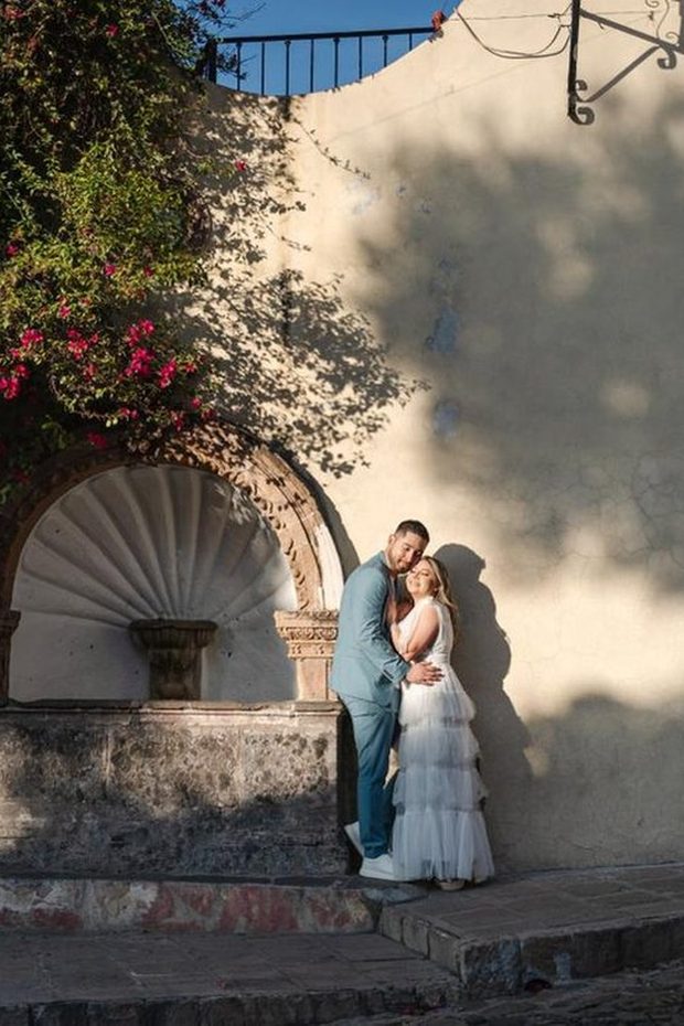 Novios en una sesión de pareja junto a una fuente de cantera